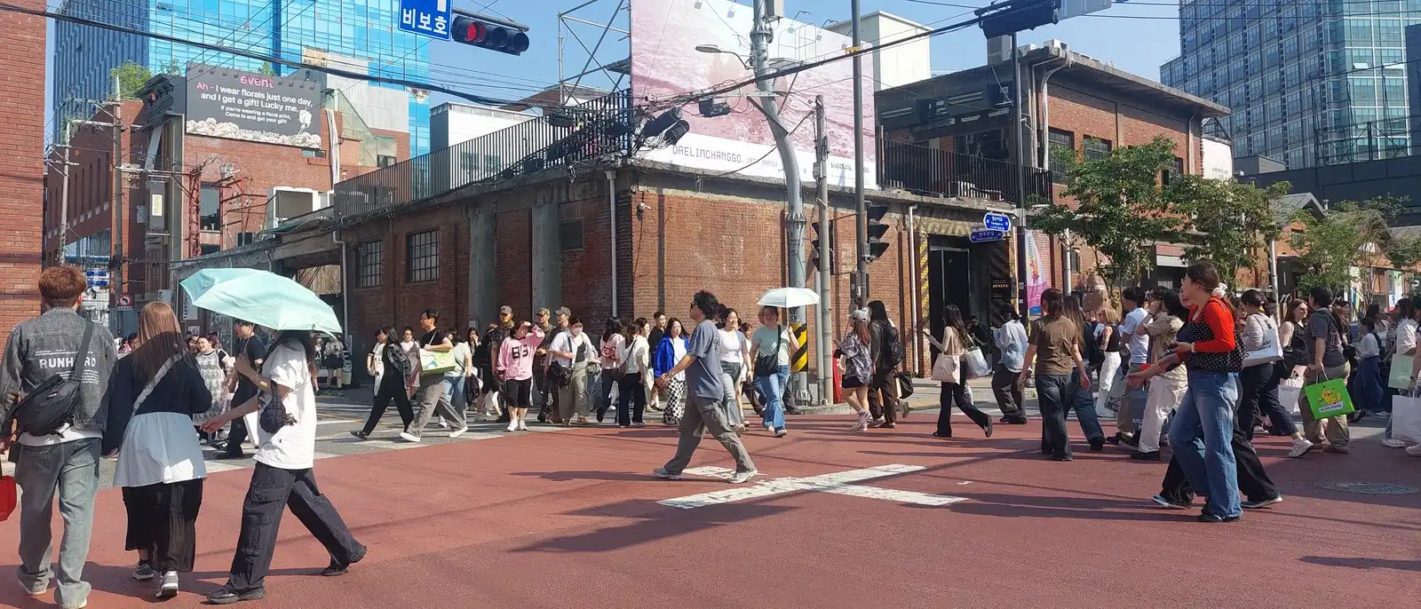 A crowded crosswalk among red-brick warehouses in Seongsu-dong, Seoul, photographed during Chainjee fieldwork